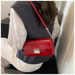 Close-up of stylish red rectangular crossbody bag with silver twist lock and chain strap