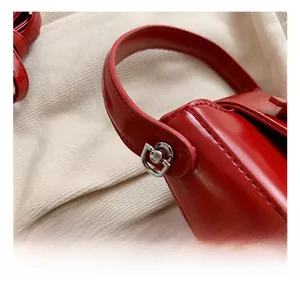 Close-up of red PU leather bag with premium silver hardware and precision stitching details