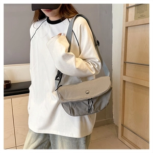 Detail of grey washed fabric crossbody bag with wide strap and double zipper pulls
