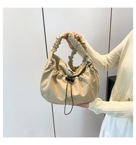 Detailed shot of the scrunchie handle and drawstring design on the khaki hobo bag