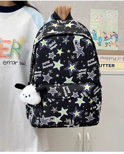 Detailed view of black nylon backpack with star prints and a plush puppy charm