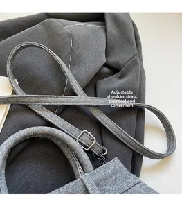 Détail du sac bandoulière en denim bleu clair avec bandoulière réglable et boucle métallique