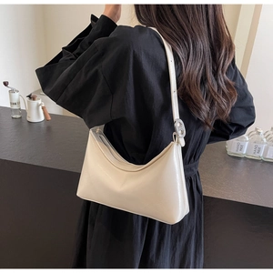 Detail view of cream white PU leather Hobo shoulder bag with metallic H-clasp on model