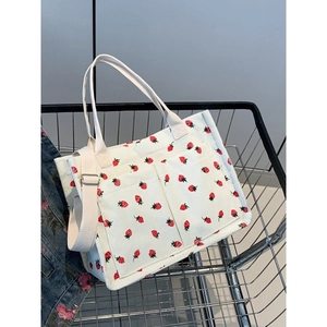 Corduroy tote bag with strawberry print featuring dual handles and adjustable strap