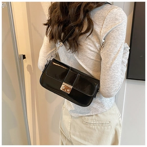 Detail of black faux leather shoulder bag with silver square buckle and metal chain links