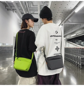 Detail view of water-resistant nylon crossbody bags in lime green and charcoal grey colors