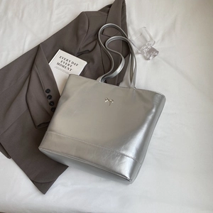 Silver metallic PU leather tote bag with bow detail and long straps for versatile shoulder wear