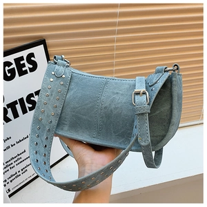 Gros plan sac à épaule Y2K en denim bleu clair avec rivets argentés et large bandoulière