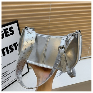 Détail du sac à épaule argenté métallisé avec rivets punk et large bandoulière réglable