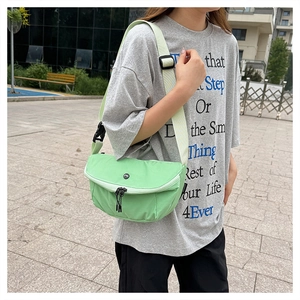 Detail view of mint green washed canvas crossbody bag with adjustable wide strap on model