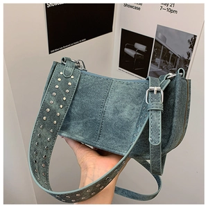 Détail du sac bandoulière en jean bleu avec rivets argentés et boucle réglable