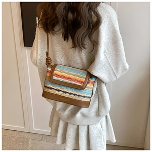 Vue détaillée du dos d'un sac bandoulière en paille colorée avec bordure en cuir brun