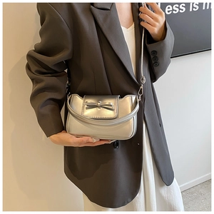 Silver matte metal handbag with elegant bow decoration and metal chain shown on a model