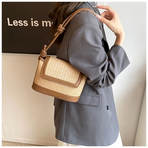 Détail du sac à bandoulière en paille et cuir marron avec bandoulière à nœuds chic