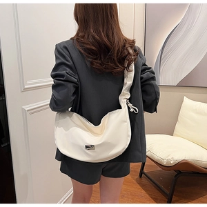 Detail of white PU leather half moon bag featuring a unique drawstring ruched shoulder strap