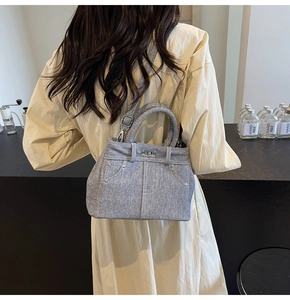 Détail du sac bandoulière bleu clair texture denim avec boucle argentée et bandoulière