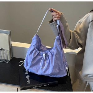 Detailed view of the light purple pleated nylon crossbody bag with drawstring closure