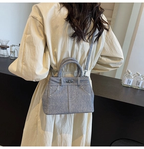 Détail du sac à bandoulière en denim avec design de poche jean et serrure en métal