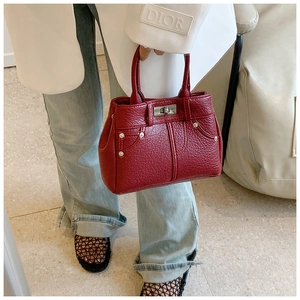 Detail einer roten Handtasche aus genarbtem Leder mit silbernem Drehverschluss