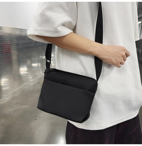 Detail of black waterproof crossbody bag with adjustable strap and zipper pockets
