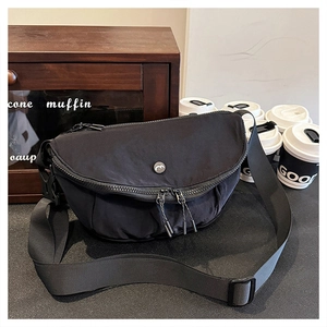 Minimalist black crescent crossbody bag in washed nylon with adjustable wide strap