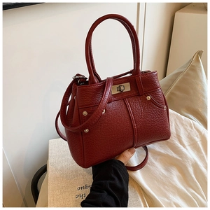 Detailansicht der dunkelroten PU-Handtasche mit Litschistruktur, Schloss und Silbernieten
