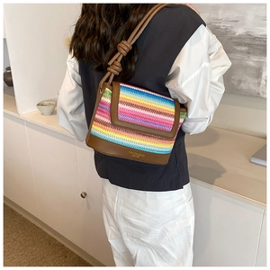 Détail d'un sac bandoulière tissé coloré avec bordure en cuir et sangle nouée sur mannequin
