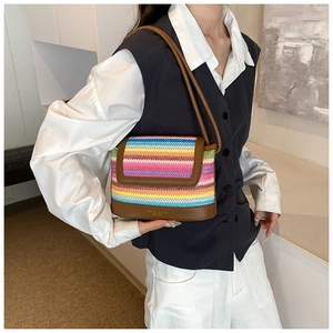 Détail d'un sac bandoulière en paille tissée colorée avec bordure en cuir marron