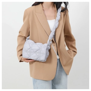 Detail of light purple quilted nylon crossbody bag with soft padded strap and flap closure