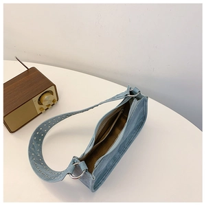 Vue détaillée du sac baguette bleu clair avec bandoulière à œillets et poche zippée interne
