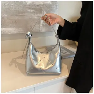 Détail du sac hobo argenté avec motif matelassé en losange et accents de clous en métal