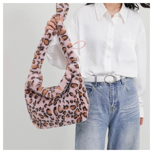 Detailed texture of pink leopard print faux fur shoulder bag worn by model