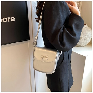 Detail view of silver PU leather crossbody bag featuring a unique knotted shoulder strap