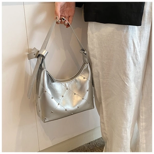 Détails d'un sac hobo argenté avec motif matelassé et rivets décoratifs