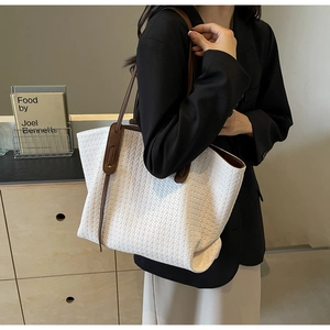 Detailed view of white woven PU leather tote bag with contrasting dark brown straps