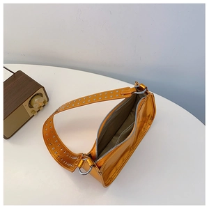 Vue détaillée du sac porté épaule orange métallisé avec rivets argentés et doublure grise