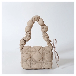 Close-up of beige quilted puffy cloud bag with ruched handle and lattice texture