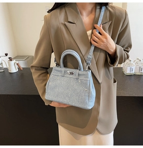 Détail du sac bandoulière en jean bleu clair avec fermoir argenté et sangle amovible