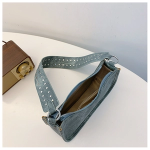 Détail d'un sac sous le bras vintage bleu foncé avec large bandoulière à rivets argentés