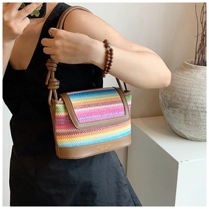 Détail du sac bandoulière tissé arc-en-ciel avec garniture en cuir brun et gaufrage