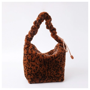 Detailed view of leopard print plush handbag featuring a scrunchie handle and drawstring