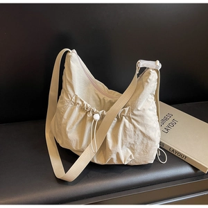 Minimalist beige nylon crossbody bag with drawstring pocket and thick shoulder strap