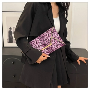Close-up of pink leopard print clutch with elegant golden V-shaped metal trim on envelope flap