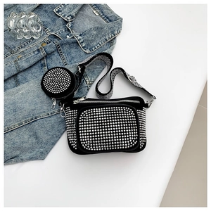 Black PU crossbody bag with silver studs and striped strap on a denim jacket background