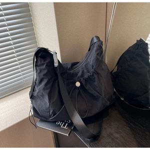 Minimalist black nylon crescent hobo bag with adjustable strap and drawstring closure
