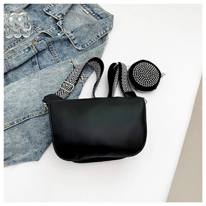 Minimalist black PU leather crossbody bag with striped strap and studded round coin purse