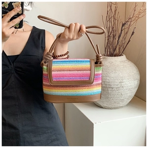 Vue détaillée du sac bandoulière en paille arc-en-ciel avec garniture en cuir marron