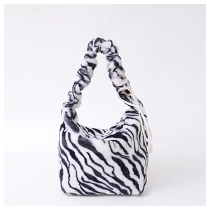 Detailed view of the zebra print faux fur texture and ruched handle on the tote bag