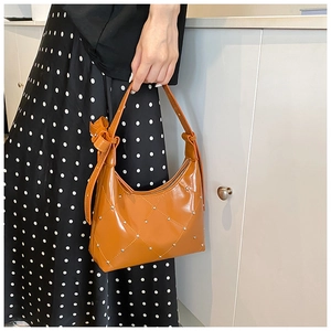 Détail du sac sous le bras en cuir PU marron matelassé avec rivets et décor de nœud
