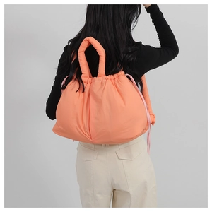 Detail of orange quilted puffer tote bag with pink drawstring and soft padded handle